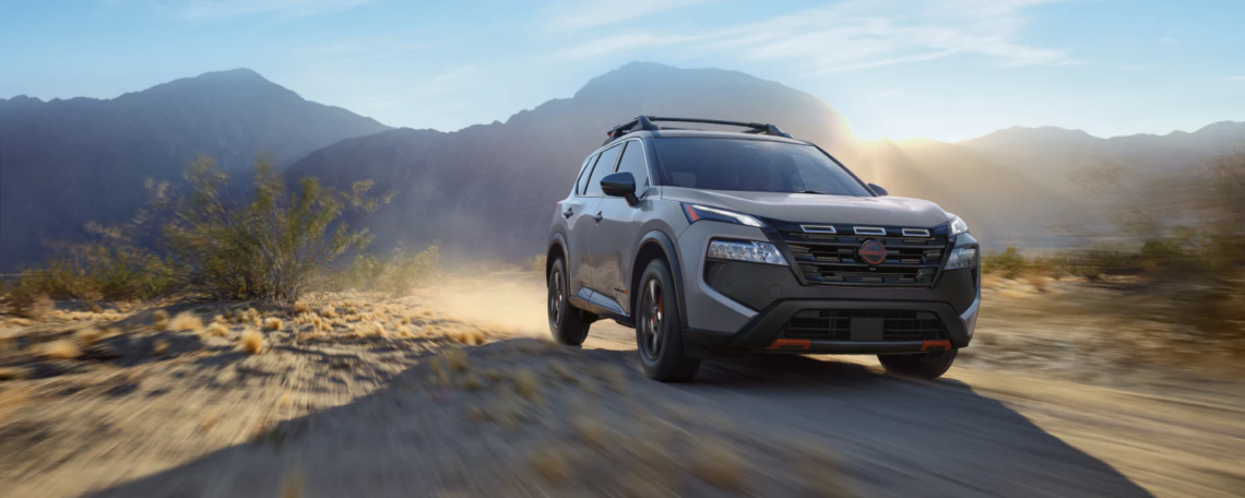 The 2026 Nissan Rogue driving in front of a mountain range