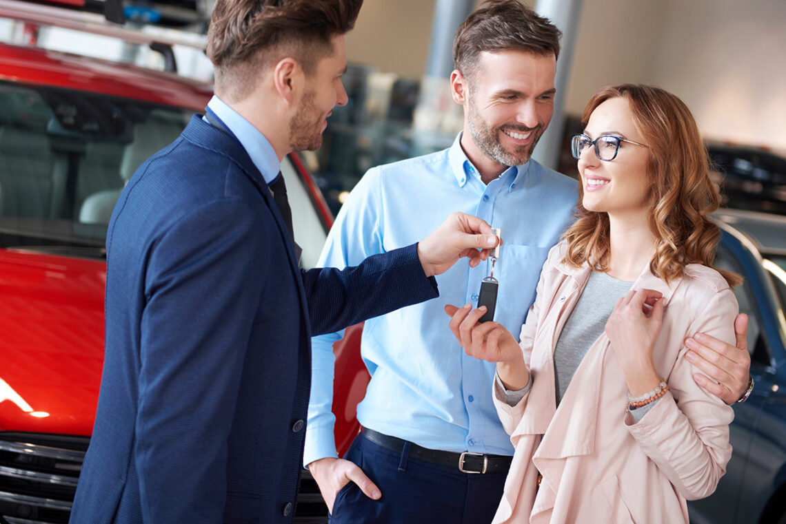 Customer receiving keys at a Nissan dealership